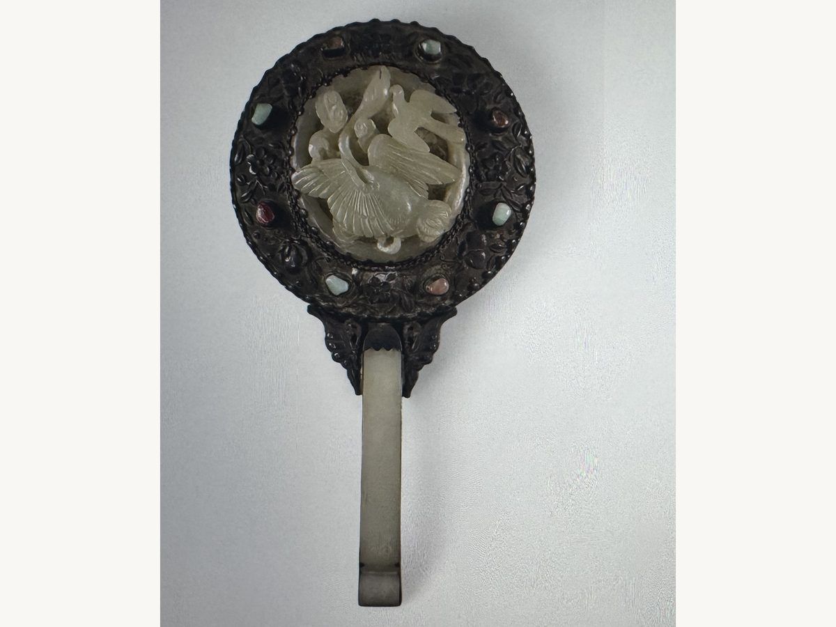 Chinese hand mirror with a carved pale stone center, jeweled dark frame and long carved handle