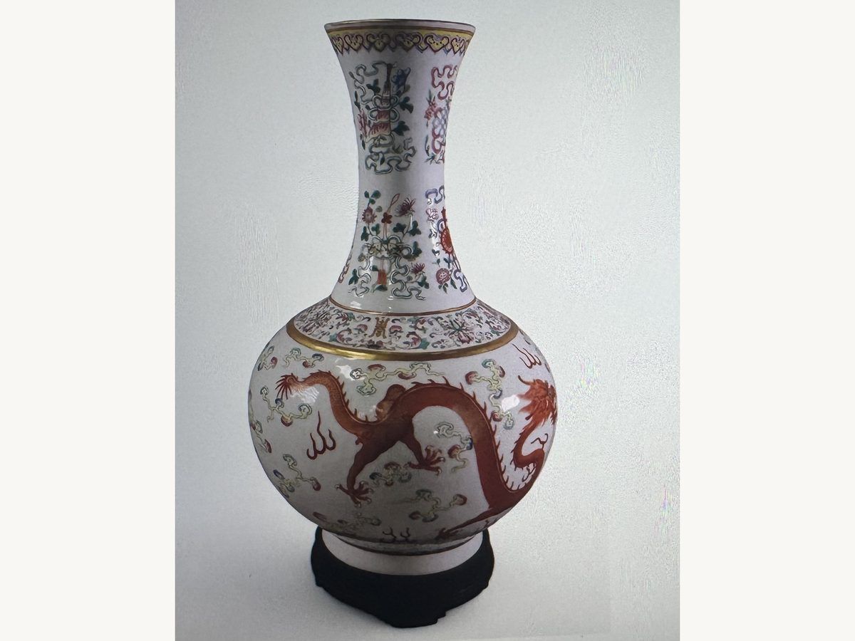 Chinese porcelain bottle vase painted with red dragons and floral bands, on a wooden stand