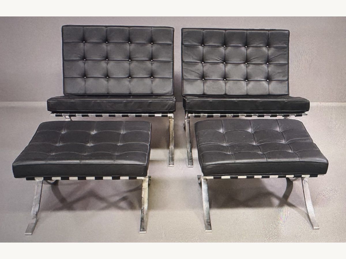 Pair of black leather Mies van der Rohe Barcelona chairs with matching ottomans, by Knoll