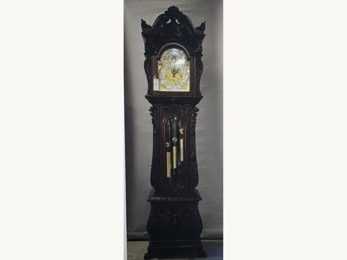 Heavily carved dark wood R.J. Horner grandfather clock with a brass dial and pendulum